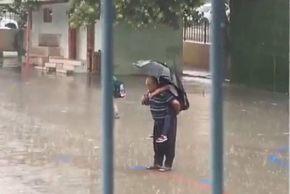 Adana’da ismi öğrenilemeyen dede, yağmur altında torununu sırtına alıp, İstiklal