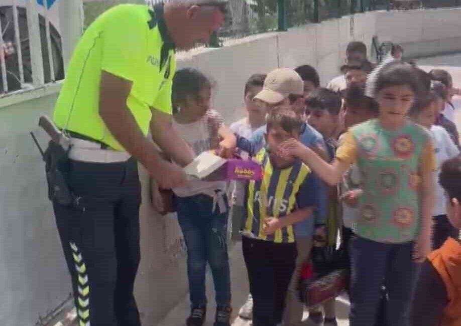 Hatay’da polis ekiplerinin okul önünde sıra olan öğrencilere çikolata dağıttığı