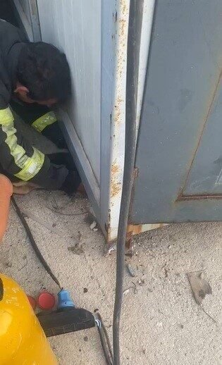 Hatay’ın Samandağ ilçesinde konteynerin altında sıkışıp mahsur kalan yavru köpek,