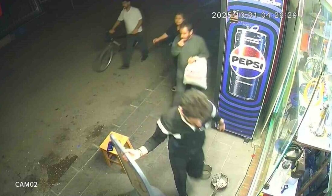 Adana’da kaldırımda yürürken çekirdek çitleyen bir kişi, dükkanın önündeki taburenin