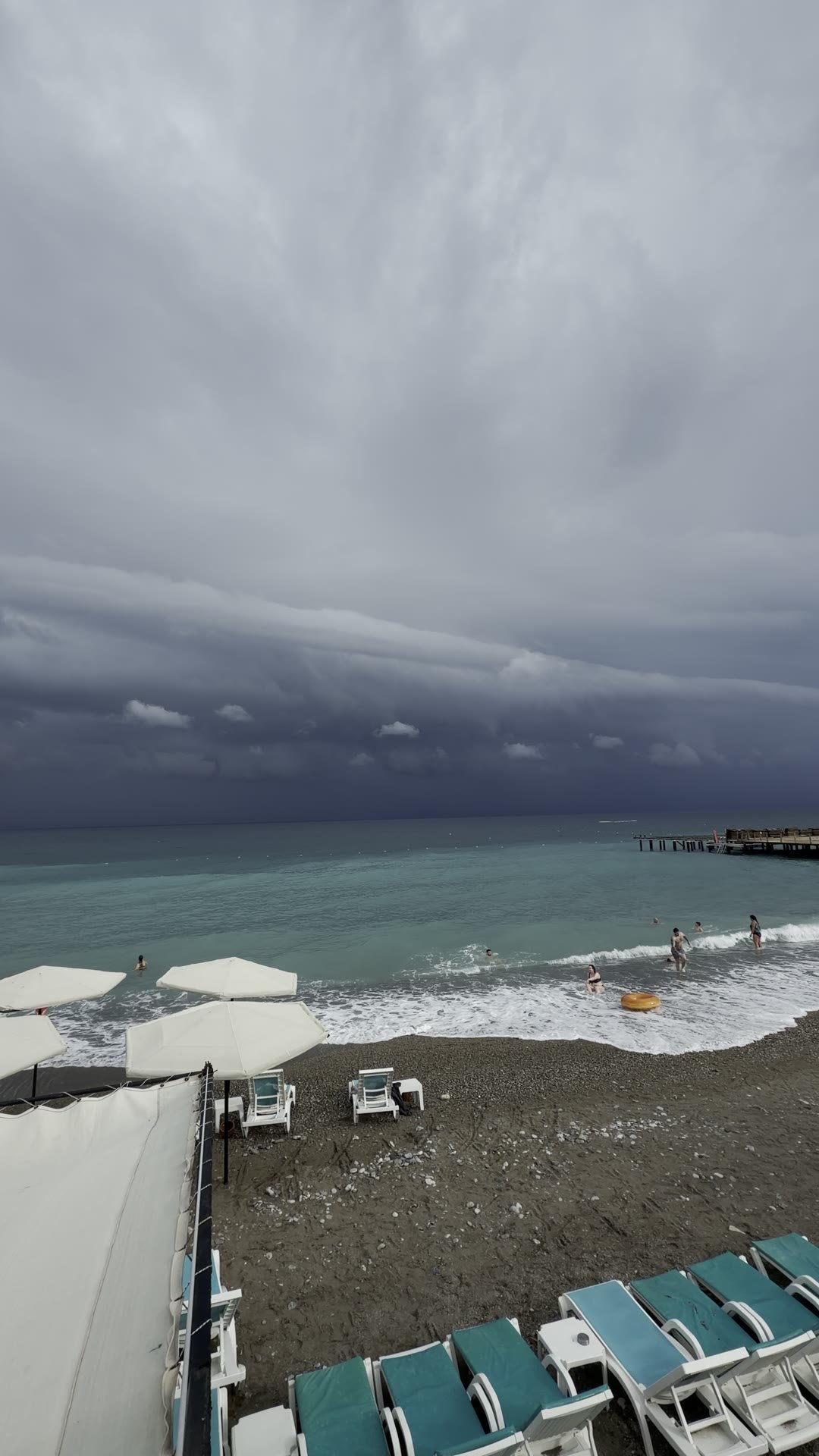 Kara bulutlara rağmen Belek'te denize girenler