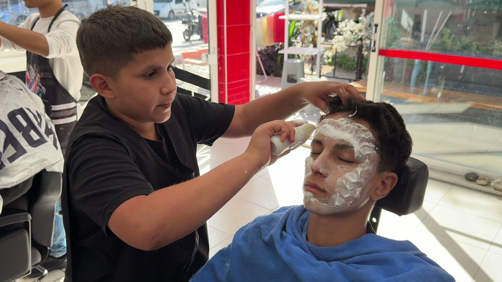 Ali Ekber Şaşa, müşterisine yüz maskesi yapıyor