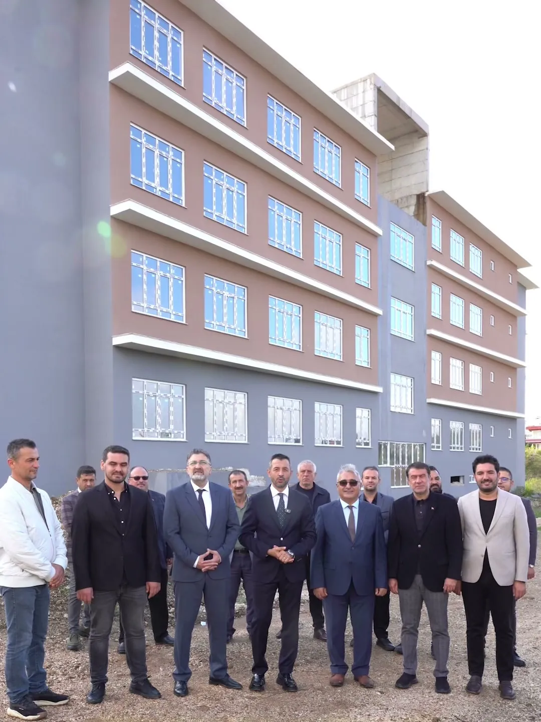 Kırbıyık Ortaokulu inşaatını inceleyen heyet okul binası önünde